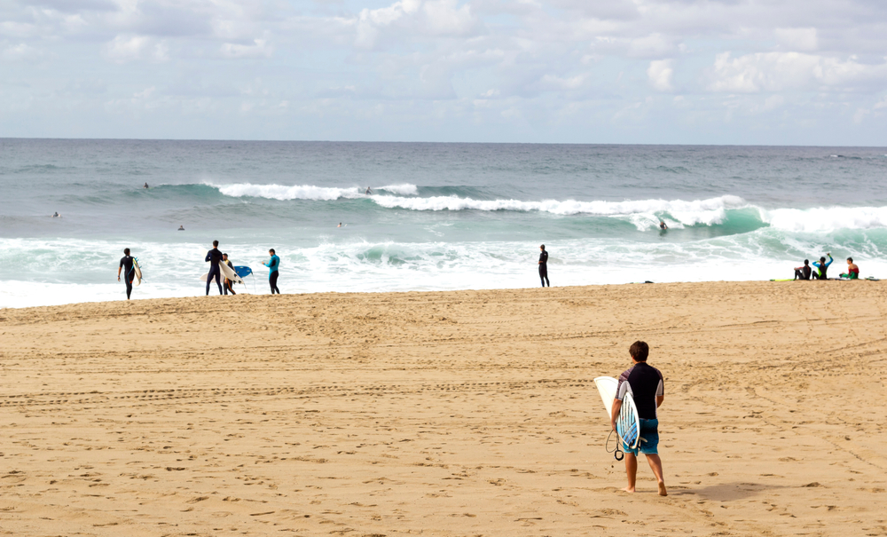 Unrecognizable,Surfer,Holding,His,Surf board,Walking,Towards,The,Sea,At