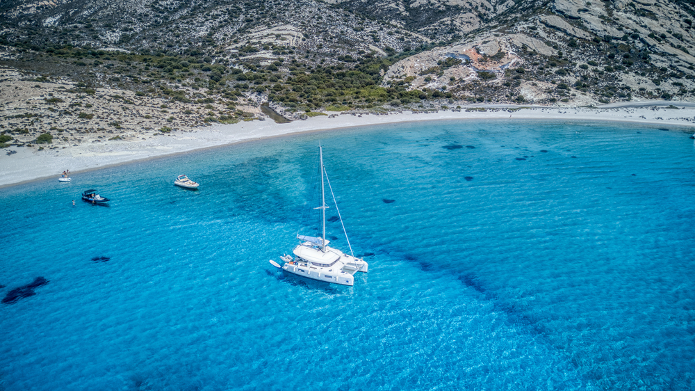 A,Sailing,Catamaran,Anchored,In,A,Turquoise,Blue,Bay,On