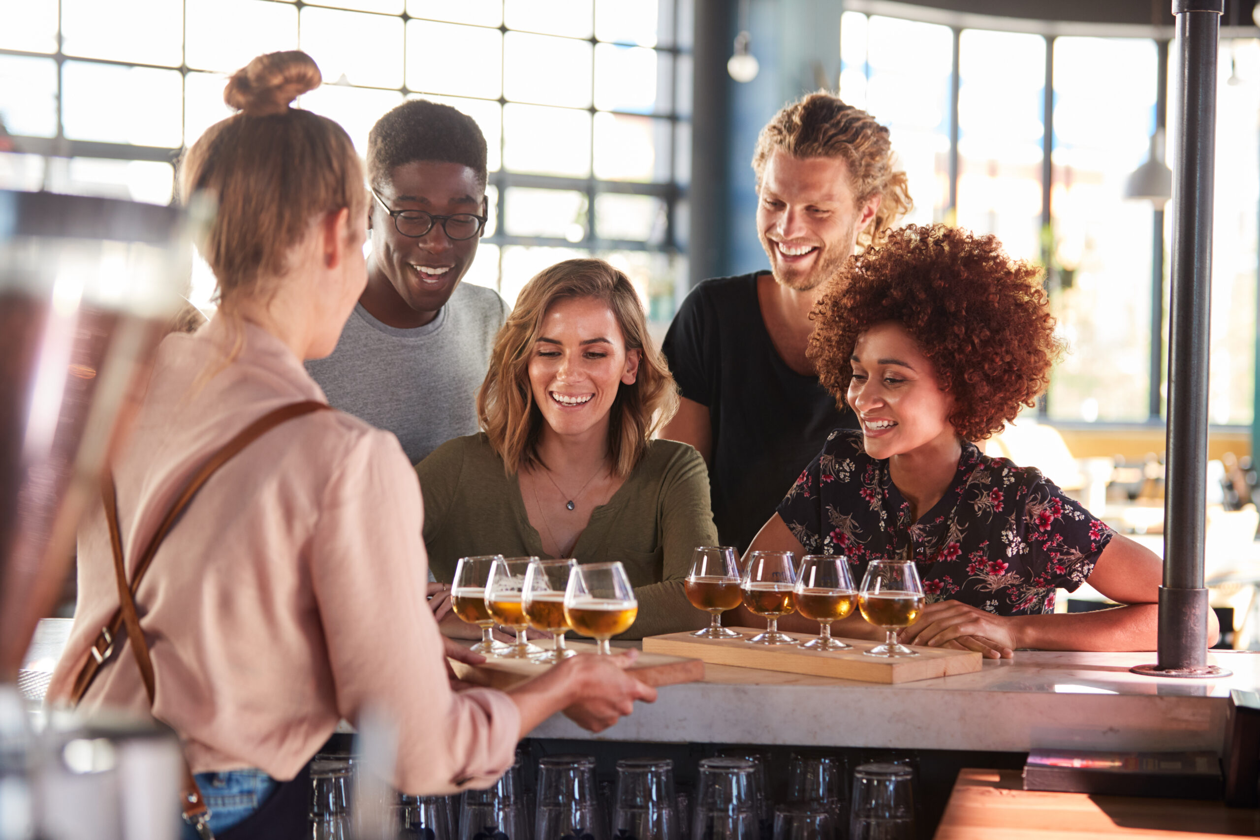 Waitress,Serving,Group,Of,Friends,Beer,Tasting,In,Bar