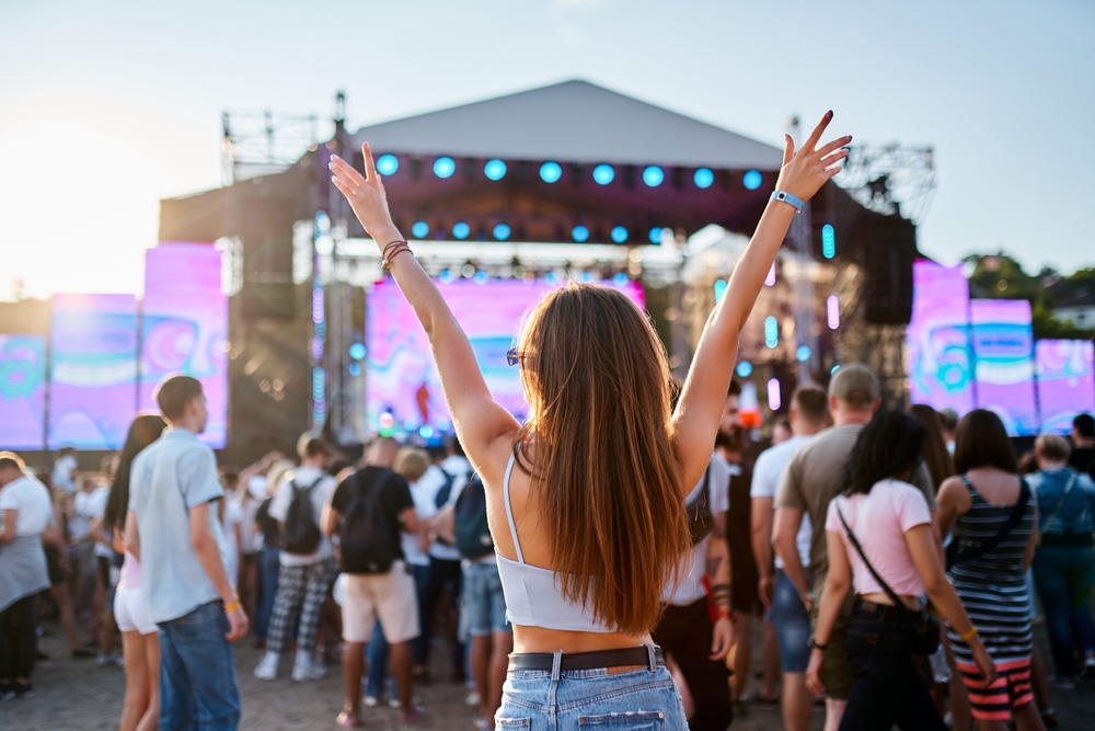 Back,View,Of,Girl,With,Raised,Arms,,Enjoying,Live,Music