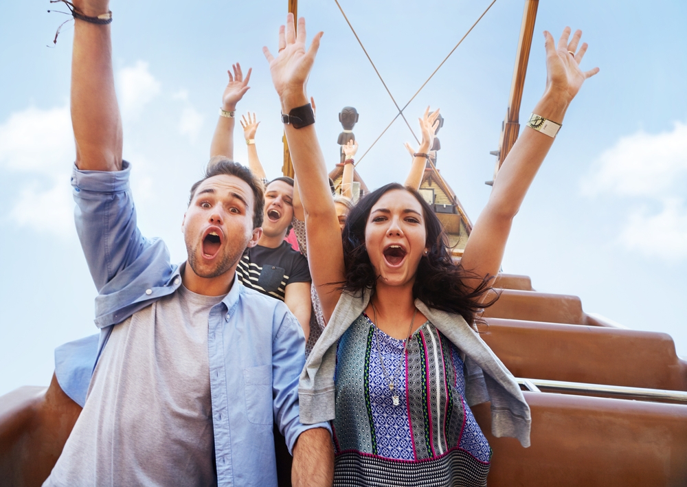 Portrait,Enthusiastic,Friends,Cheering,On,Amusement,Park,Ride