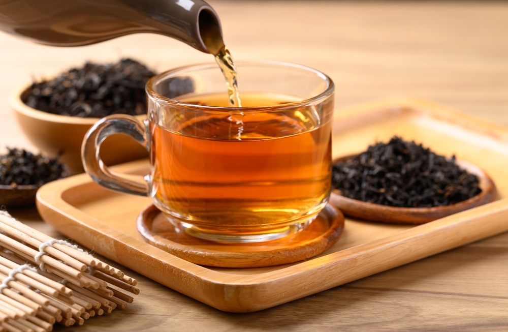 Black,Tea,In,Cup,Glass,With,Teapot,Pouring,Tea,,Healthy
