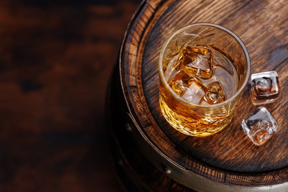 Whiskey,Glass,With,Ice,On,A,Rustic,Barrel,,A,Classic